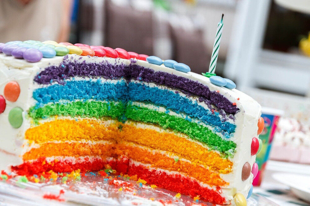 Bunter Geburtstagskuchen mit verschiedenen Etagen in den Farben des Regenbogens