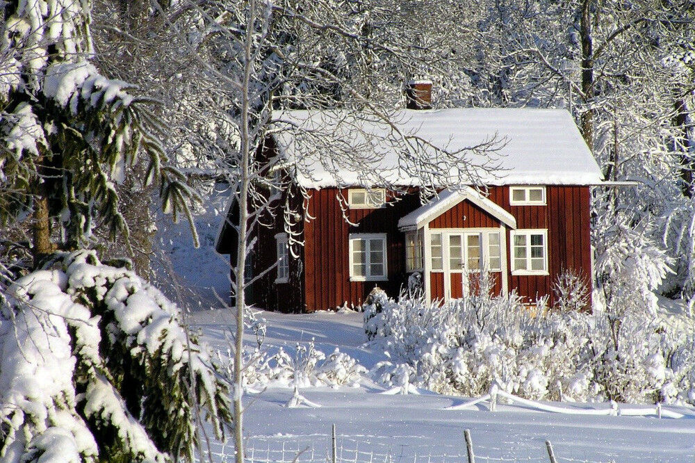 Rotes Haus in einer verschneiten Winterlandschaft