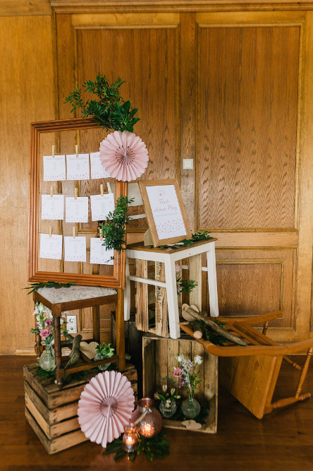 Hochzeitsdekoration bestehend aus Holzkisten und Glückwunschkarten in einem Rahmen