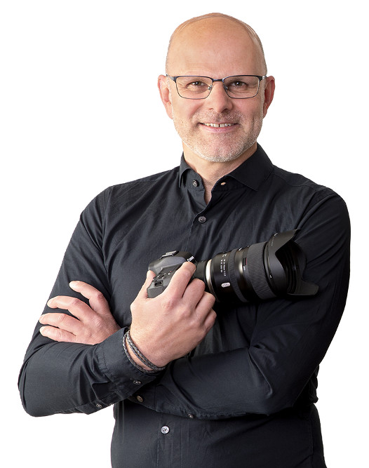 Portraitfoto von Holger Bulk mit seiner Spiegelreflex-Kamera